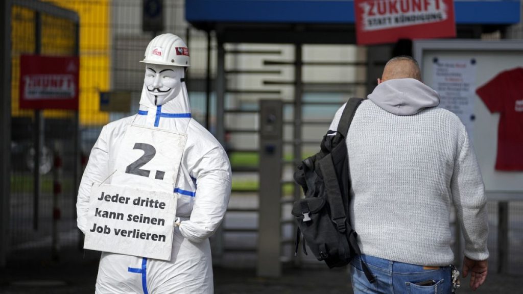 A worker enters the thyssenkrupp steelworks in Duisburg, Germany, Tuesday, Oct. 8, 2024, beside a sign of the steel union IG Metall reading