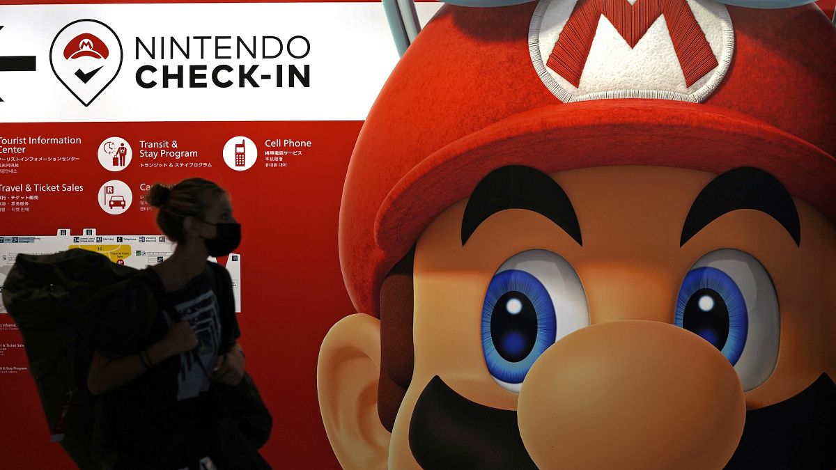 File picture of a traveller walking past an advertisement featuring a Nintendo character at Narita airport in Narita near Tokyo