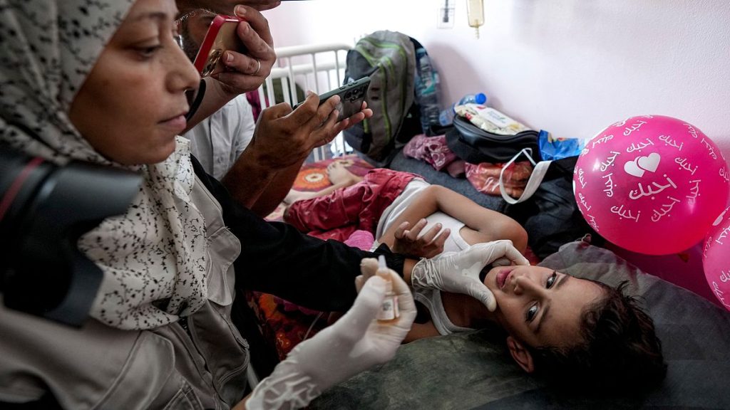 FILE PHOTO: A health worker administers a polio vaccine to a child at a hospital in Khan Younis, Saturday, Aug. 31, 2024.