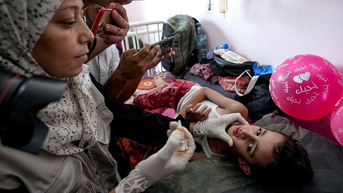 FILE PHOTO: A health worker administers a polio vaccine to a child at a hospital in Khan Younis, Saturday, Aug. 31, 2024.