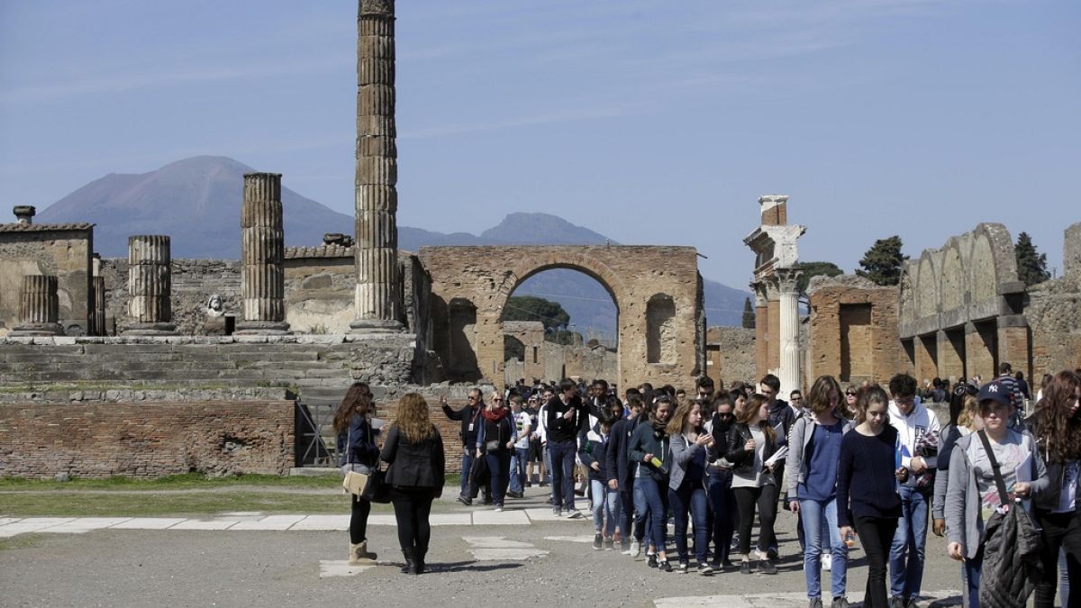 FILE - Tourists walk through Pompeii near the Villa of Mysteries in Italy, March 20, 2015. (AP Photo/Gregorio Borgia, File)