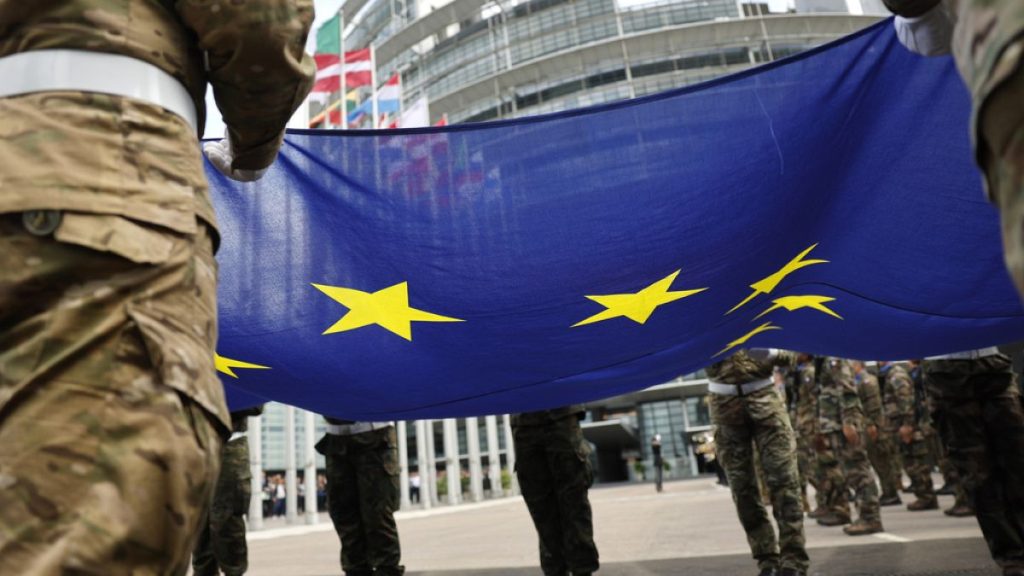 Military hold the European Union flag as they participate in a flag raising ceremony