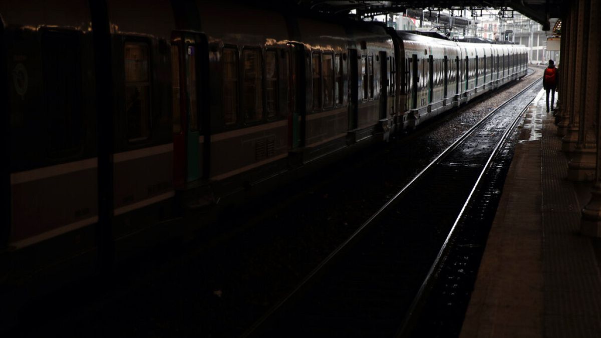 A passenger stands on empty platform of a RER suburb subway, in Paris, Dec. 8, 2019.