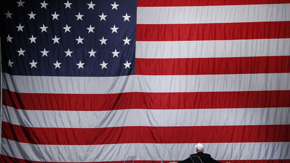 Republican presidential candidate Donald Trump turns to the flag at a campaign rally in Sterling Heights, Michigan. 6 November 2016.