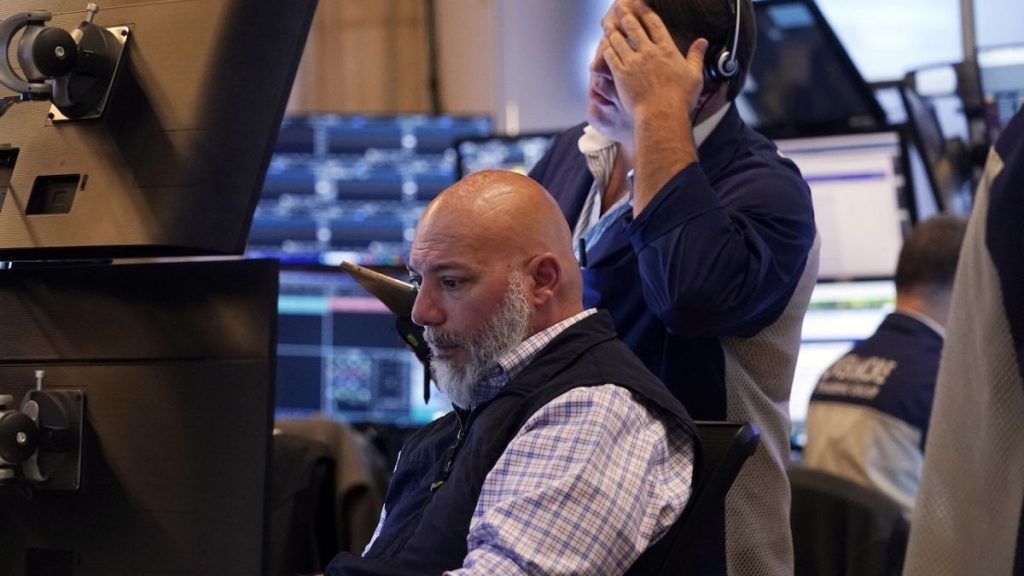 Library pictures of a pair of traders work on the floor of the New York Stock Exchange