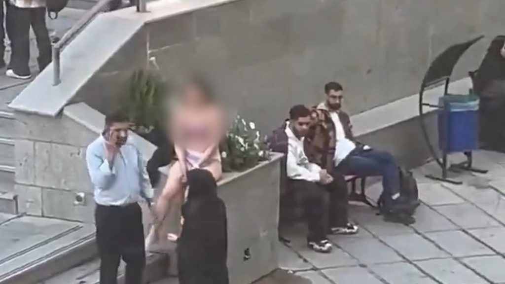 Video showing female student in Iran alongside two security guards