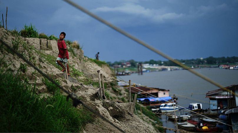 Un garçon grimpe une colline près d'un faible fleuve Amazone en raison de la sécheresse, à Leticia, Colombie, octobre 2024