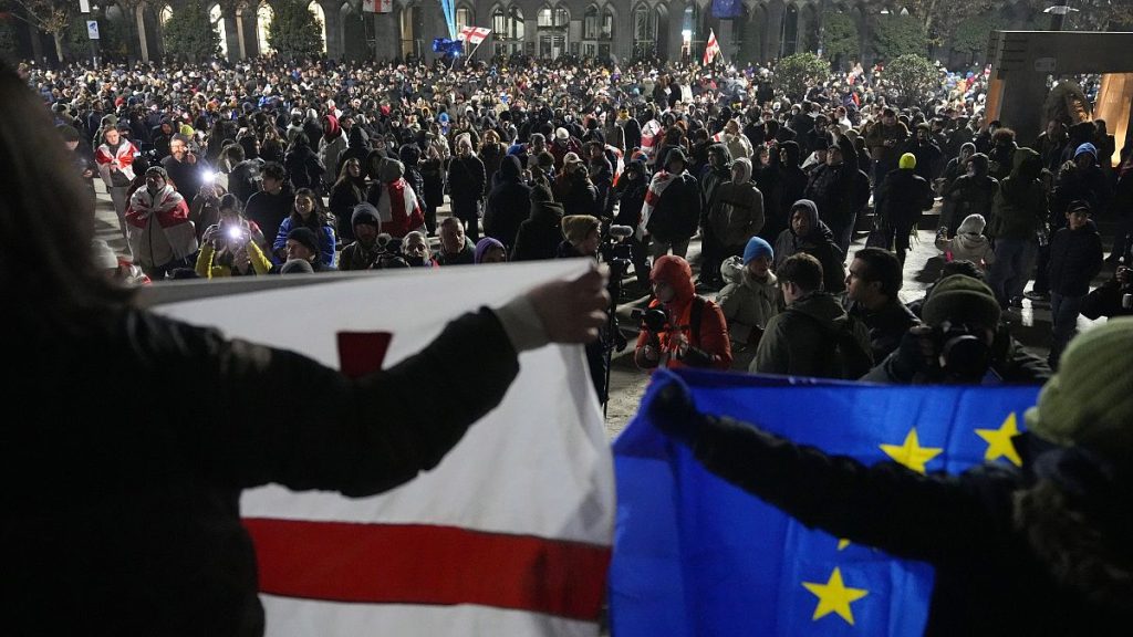 Demonstrators hold EU and Georgian flags during a rally in Tbilisi, 5 December, 2024