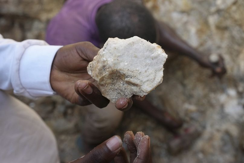 Un homme montre de la pierre de lithium provenant d'un site minier illégal à Paseli, dans le centre-nord du Nigeria, le mardi 5 novembre 2024. (AP Photo/Sunday Alamba)