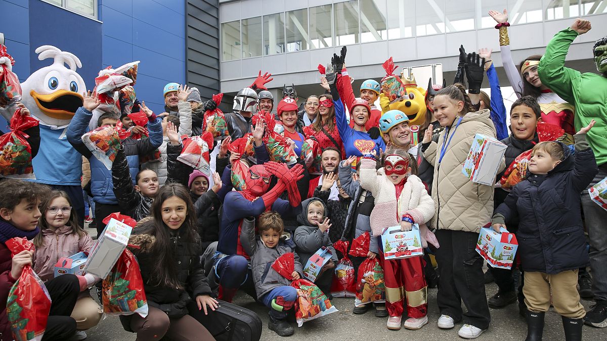 Children receive Christmas gifts from alpinists dressed as superheroes at a hospital in Pristina, 13 December, 2024