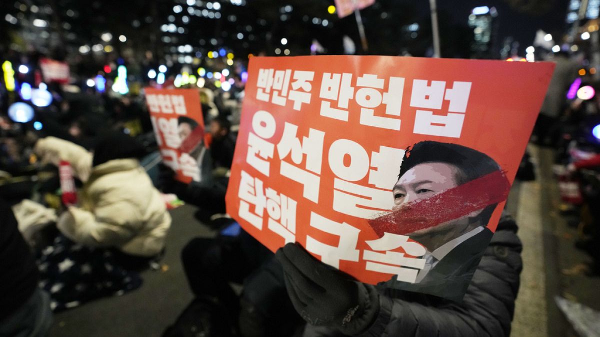 Protesters hold banners during a rally to demand South Korean President Yoon Suk Yeol