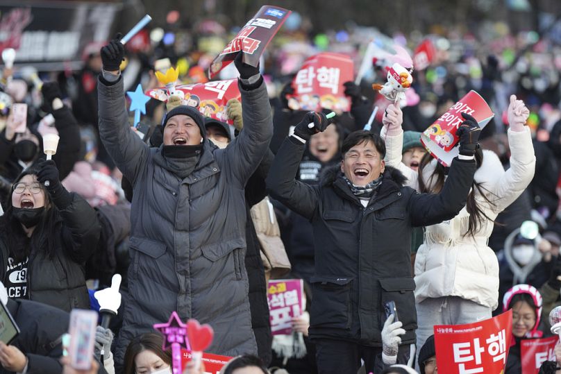 Les participants célèbrent après avoir appris que le parlement sud-coréen a voté en faveur de la destitution du président Yoon Suk-yeol