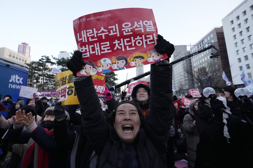 Les participants célèbrent après avoir appris que le parlement sud-coréen a voté en faveur de la destitution du président Yoon Suk-yeol