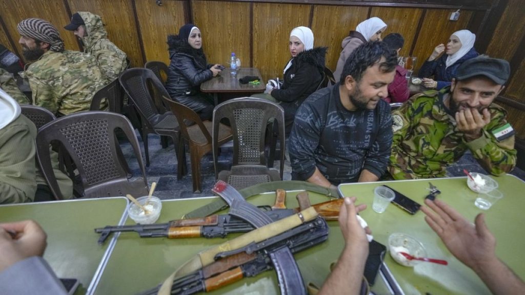 FILE - Opposition fighters sit in a restaurant at the Al-Hamidiyeh market inside the old walled city of Damascus, Syria, Tuesday, Dec. 10, 2024. (AP Photo/Hussein Malla)