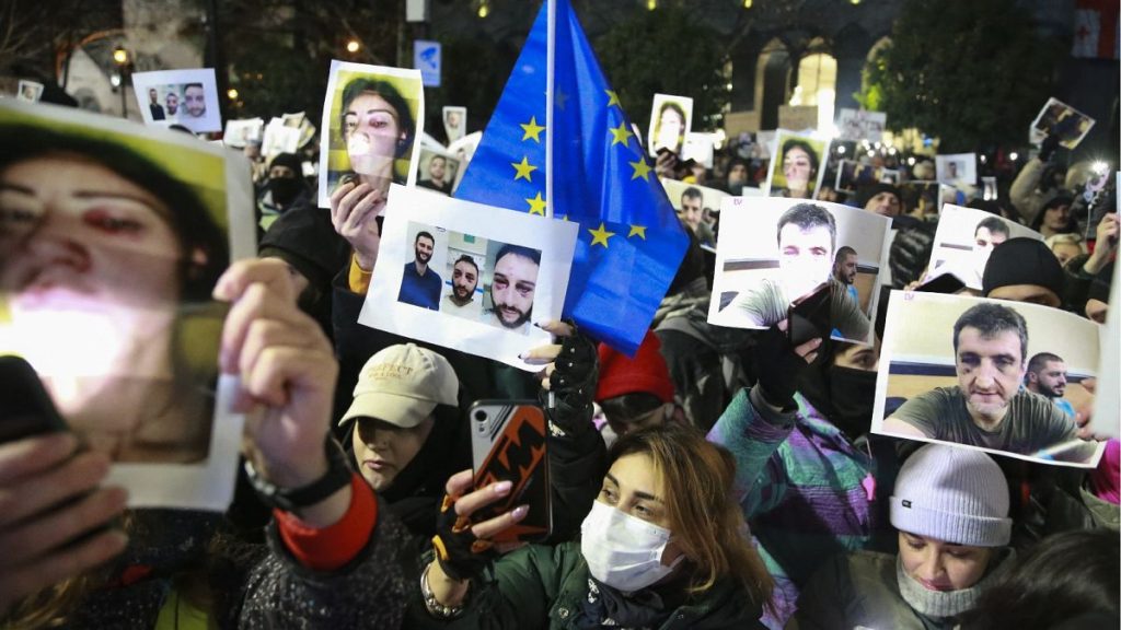 Demonstrators hold portraits of activists injured during protests during an anti-government rally outside the Parliament building in Tbilisi, Georgia, Dec. 14, 2024..