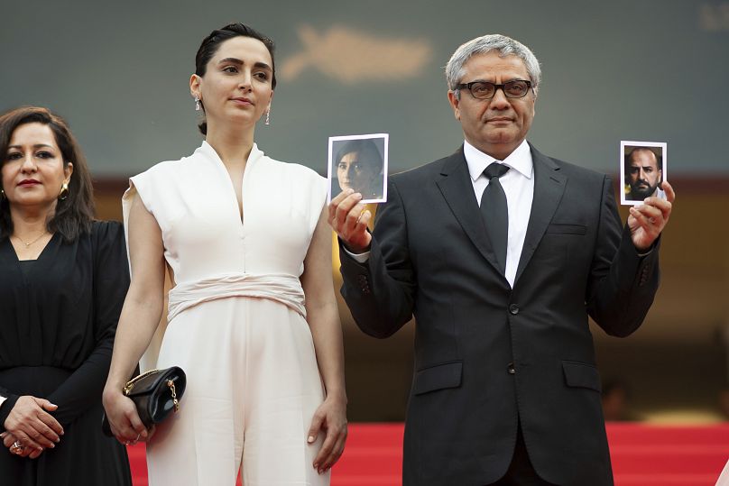 Le réalisateur Mohammad Rasoulof, à droite, tient des photographies des acteurs Missagh Zareh, à gauche, et Soheila Golestani, aux côtés de Mahsa Rostami - Cannes 2024