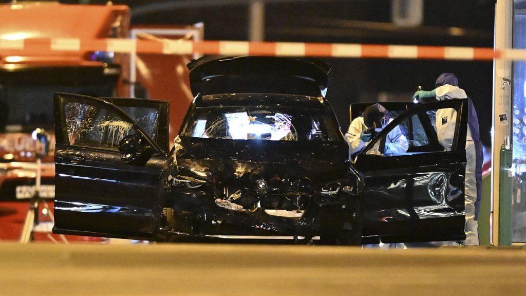 Forensics work on a damaged car sitting with its doors open after it drove into a busy Christmas market in Magdeburg, 21 December, 2024