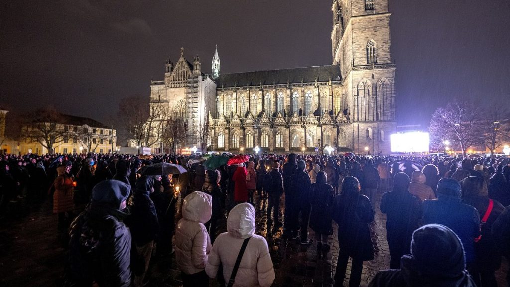 People attend a memorial service outside the cathedral close to the Christmas market where a car drove into a crowd on Friday evening, 21 December, 2024