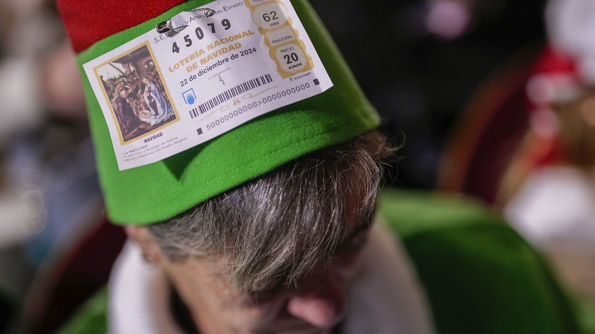 A spectator waits for the start of the annual Christmas lottery draw in Madrid, 22 December, 2024