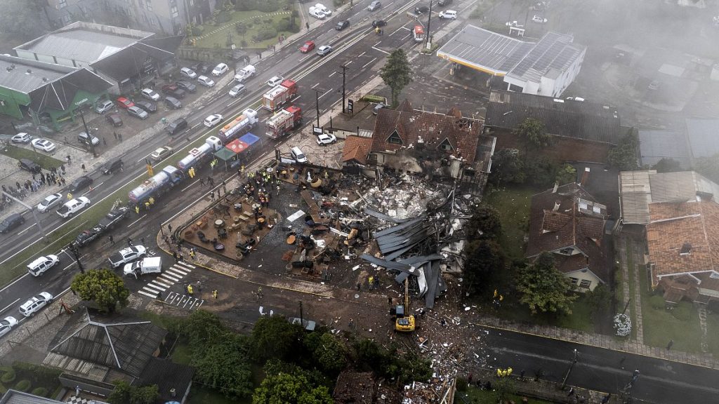 Police carry out an investigation by houses that were hit by a plane in Gramado, 22 December, 2024