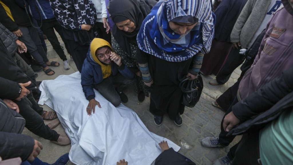 Relatives and neighbours mourn over the body of one of the victims of an Israeli strike on a hom4 late Saturday as they are prepared for the funeral outside the Al-Aqsa Martyr