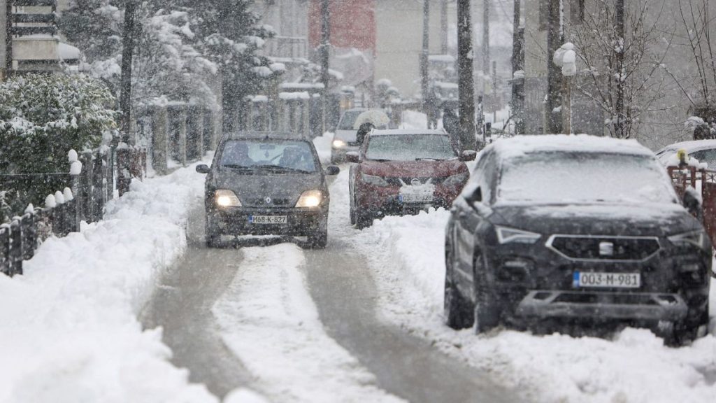 A car drives down the street during heavy snowfall in Bihac, Bosnia.