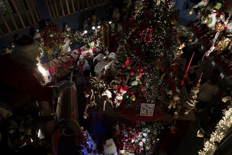 Un enfant regarde une figure du Père Noël sur un traîneau chez Kris Kringl