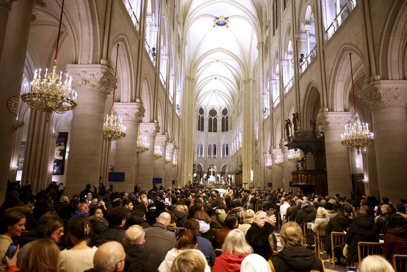 Des fidèles sont assis avant la messe à la cathédrale Notre-Dame alors que les monuments accueillent les services du réveillon de Noël pour la première fois depuis un incendie dévastateur en 2019, le mardi 24 décembre 2024.