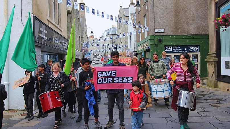 Sanjeev, Andrea et d'autres militants défilent dans les rues des Shetland