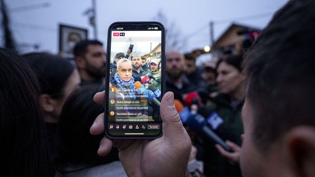 A man records video of Calin Georgescu, an independent candidate for president who won the first round of presidential elections, 8 Dec 2024.