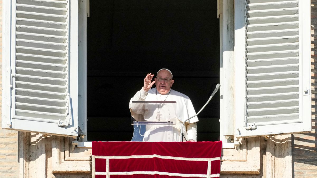 Pope Francis delivers his blessing as he recites the Angelus noon prayer from the window of his studio overlooking St.Peter