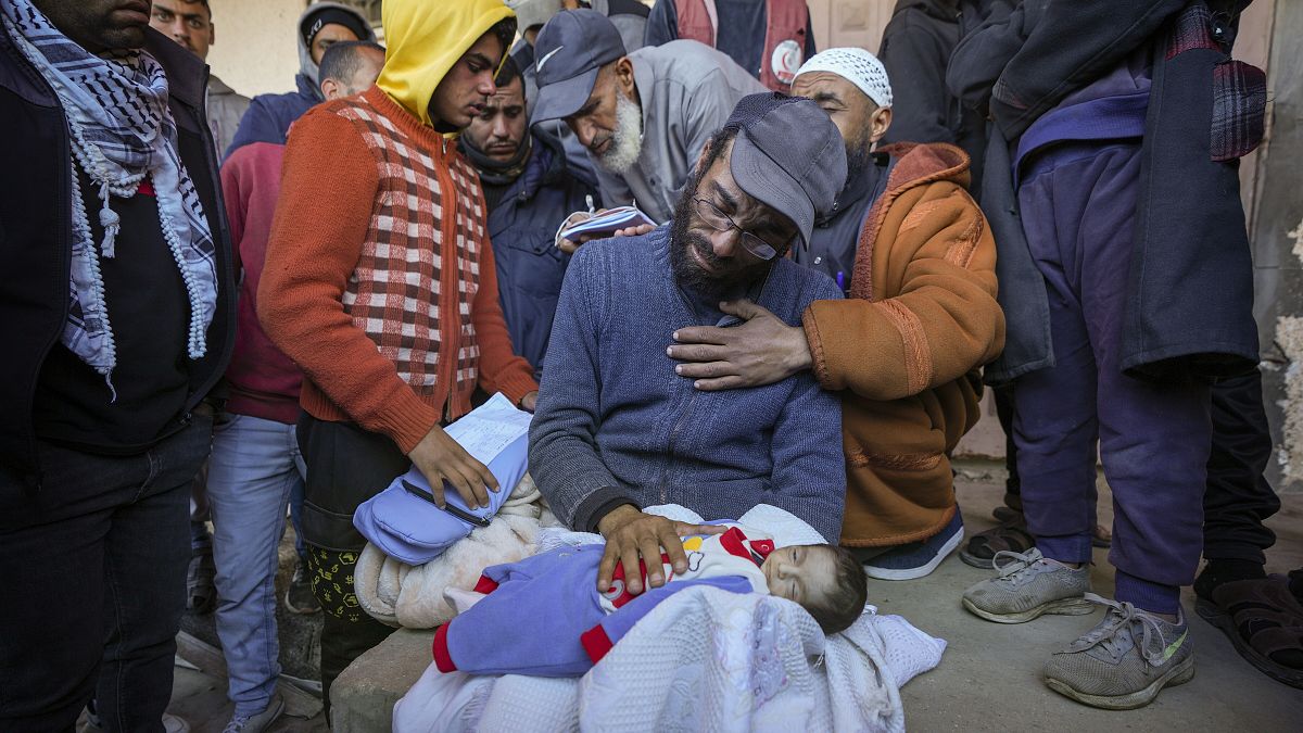 Yehia al-Batran holds the body of his 20-day-old son Jomaa who died from hypothermia in Gaza, 29 December, 2024