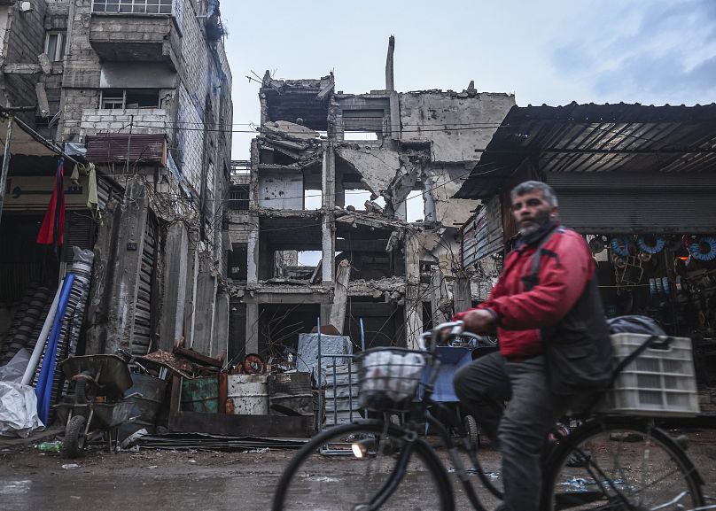 Un homme passe devant des bâtiments endommagés par les frappes aériennes pendant le régime d'Al-Assad à Douma, le 29 décembre 2024.