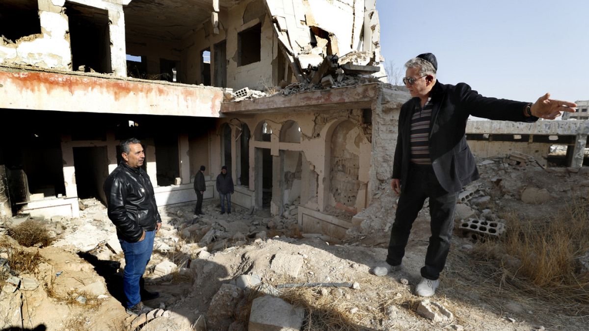 Bakhour Chamantoub, 74, right, the head of the Jewish community in Syria, speaks with a Syrian man during his visit to the destroyed Jobar Synagogue.