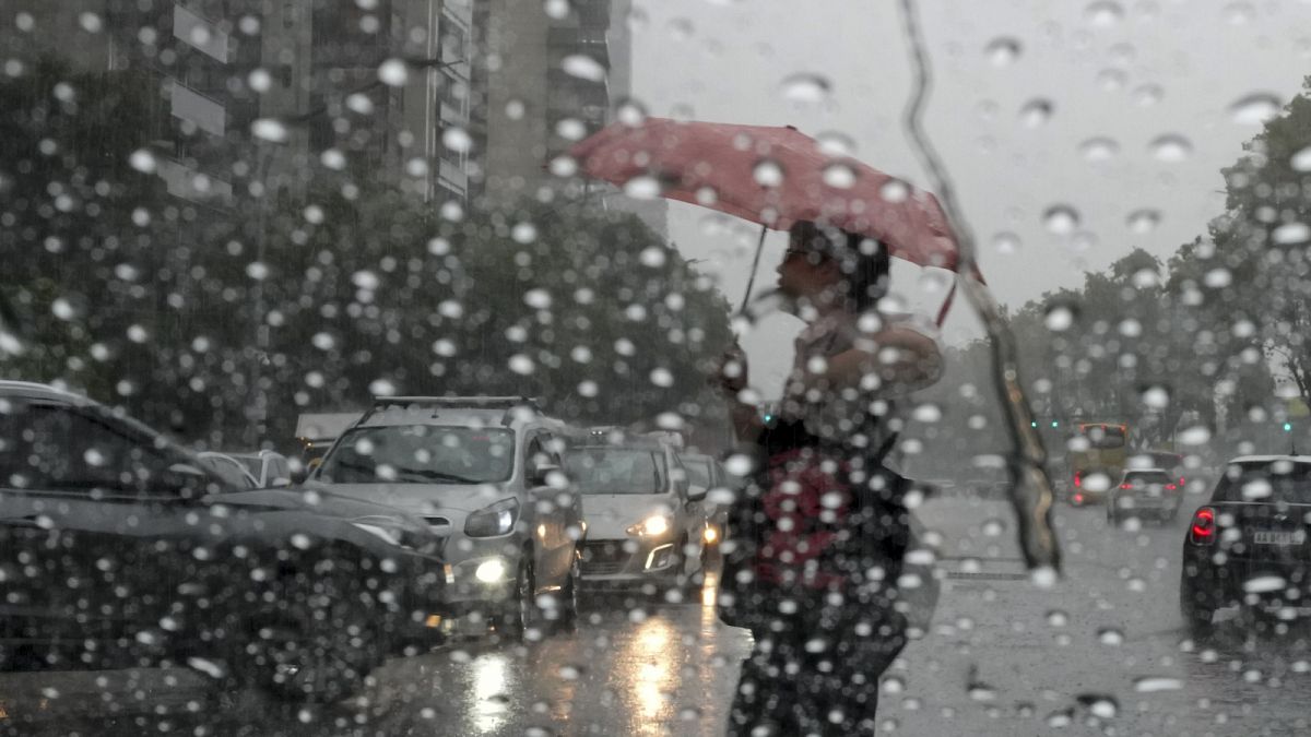 A pedestrian holding an umbrella crosses the street during a rain shower in Buenos Aires, Argentina, March 20, 2024.