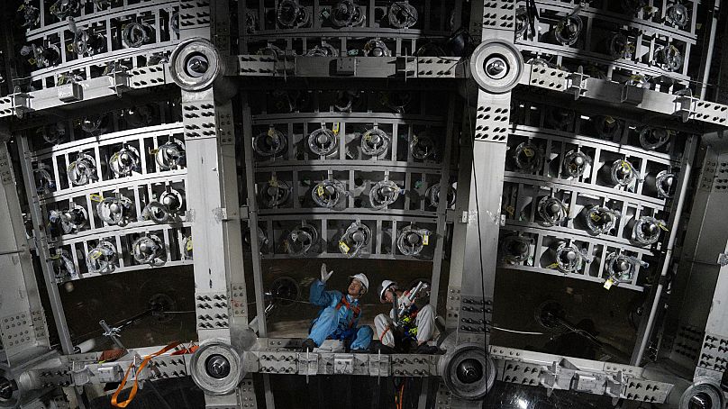 Des ouvriers travaillent sous le détecteur cosmique situé à 700 m sous terre à l’observatoire souterrain de neutrinos de Jiangmen à Kaiping, dans le sud de la Chine.