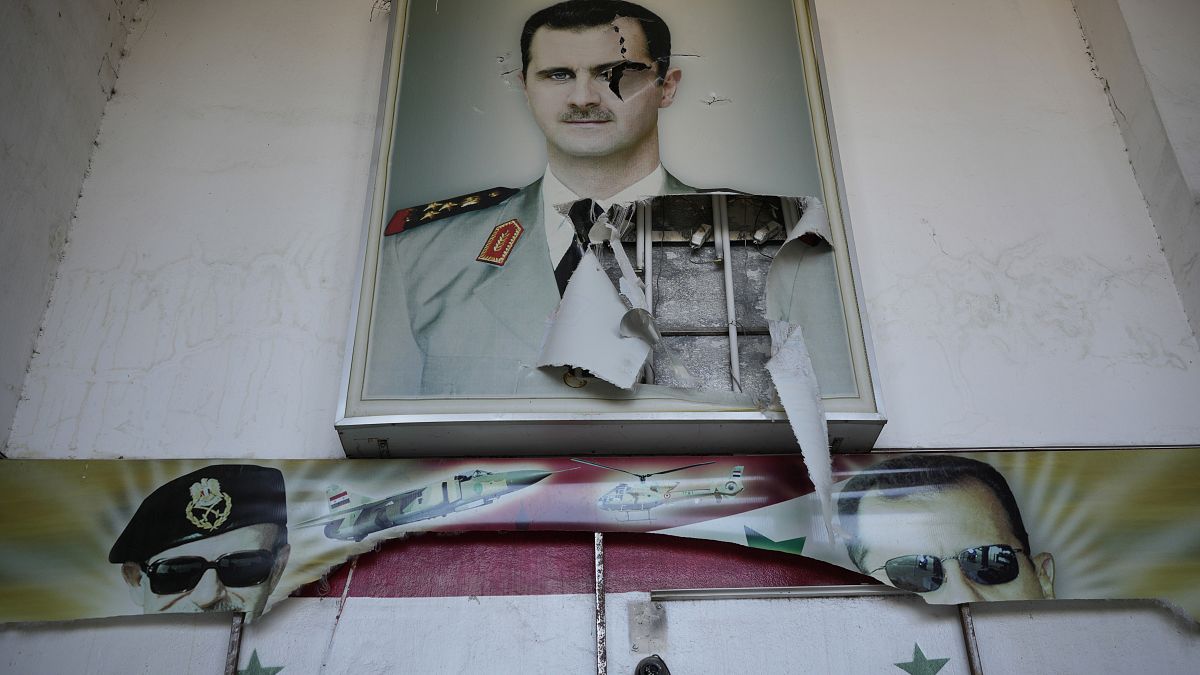 A torn poster shows ousted Syrian President Bashar Al-Assad in Damascus, Syria, (14 December 2024)