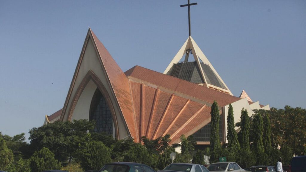 FILE - Nov. 11, 2011, a man stands in front an Inter-denominational church in modern architectural design in Abuja, Nigeria.