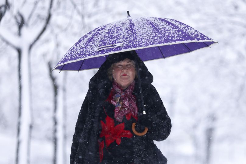 Une femme se promène dans le parc lors de fortes chutes de neige à Sarajevo, en Bosnie, le mardi 24 décembre 2024.