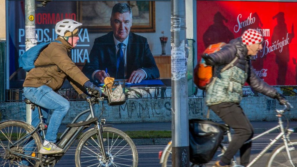 Cyclists ride past a poster of incumbent President Zoran Milanovic ahead of the presidential election in Zagreb, Croatia, Thursday, 26 December 2024