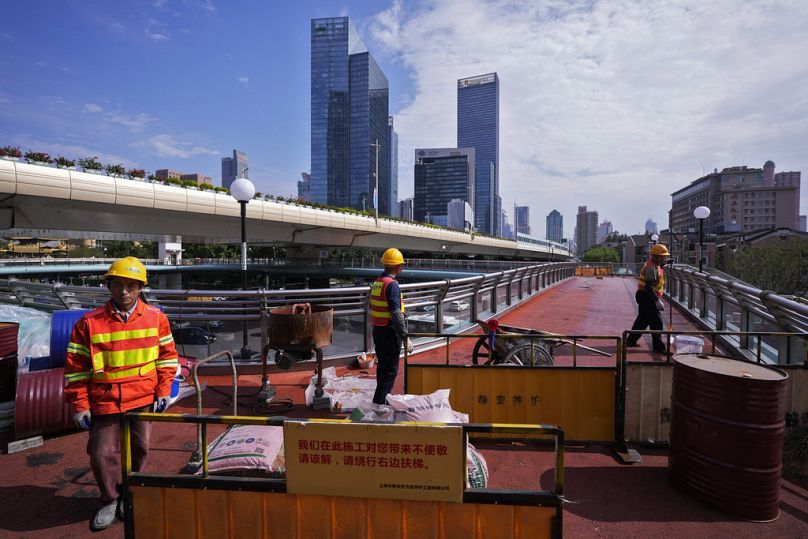 Des ouvriers rénovent un pont piétonnier à Shanghai, octobre 2024