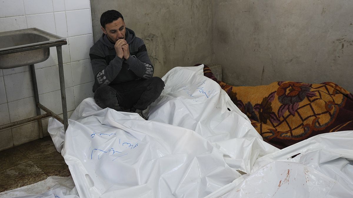 A Palestinian man sits in Al-Aqsa Hospital mourning relatives killed in overnight Israeli airstrikes on the Maghazi refugee camp on 28 December, 2024.