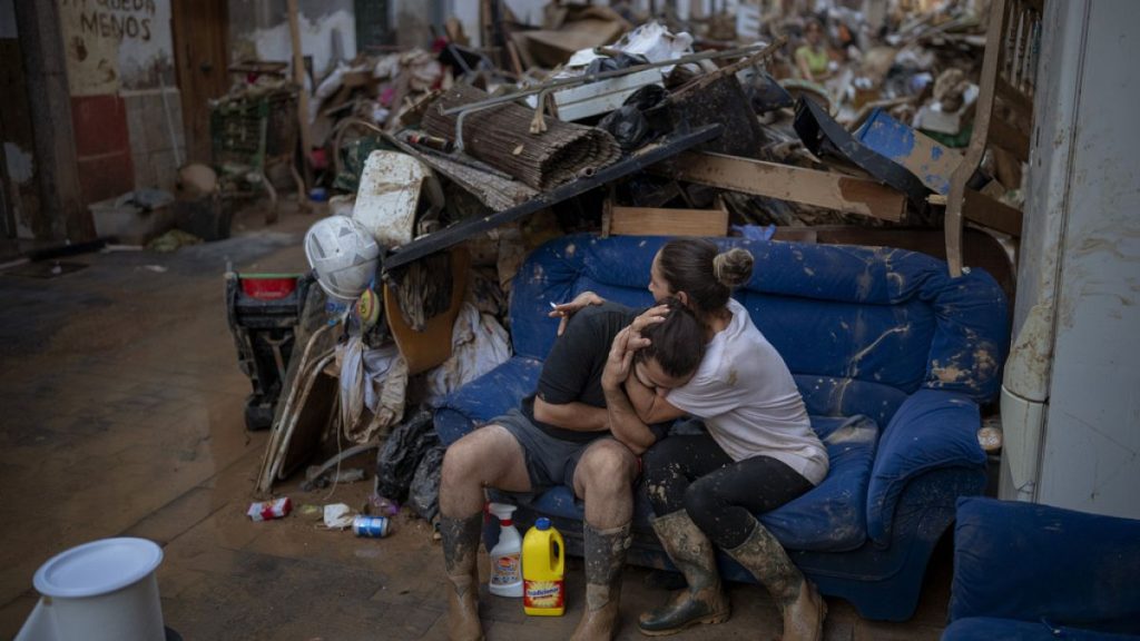 Tania hugs her brother-in-law Baruc after rescuing some of their belongings from their flooded house after the floods in Paiporta, Valencia, Spain