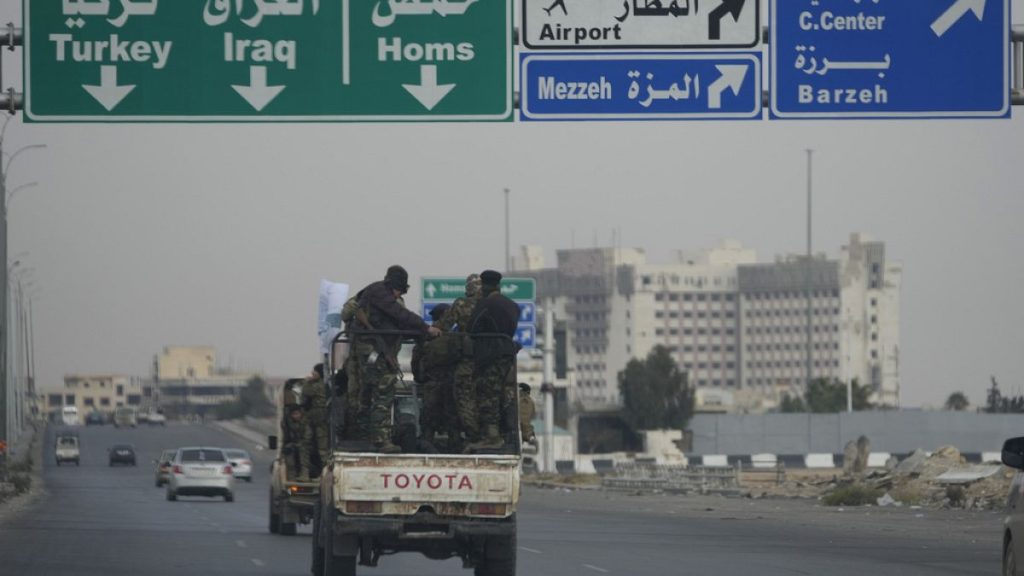 Syrian fighters travel on vehicles, as they patrol at a highway, in Damascus, Syria, Thursday, Dec. 26, 2024.