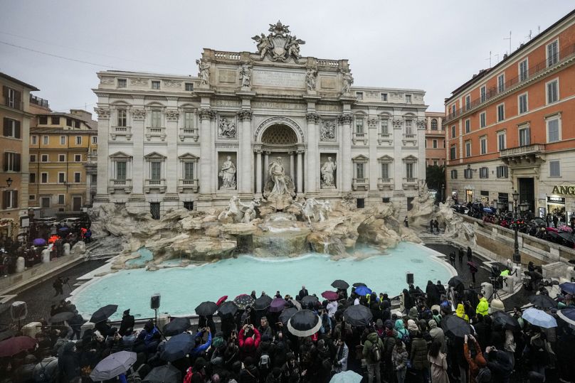 Les gens admirent la fontaine de Trevi du XVIIIe siècle, l'un des monuments les plus emblématiques de Rome, le dimanche 22 décembre 2024.