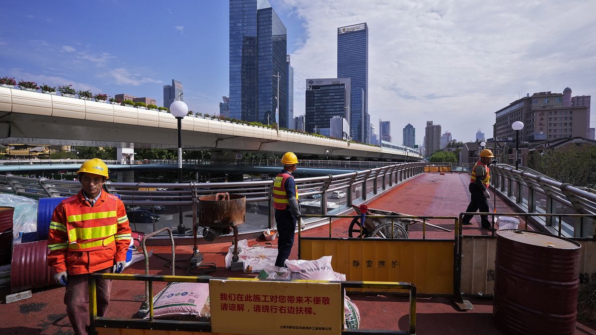 Workers in Shanghai constructing an overhead pedestrian bridge