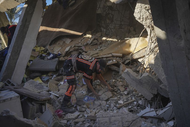 Un secouriste fouille les décombres d'un bâtiment touché par un avion israélien à Deir al-Balah, le 14 décembre 2024.