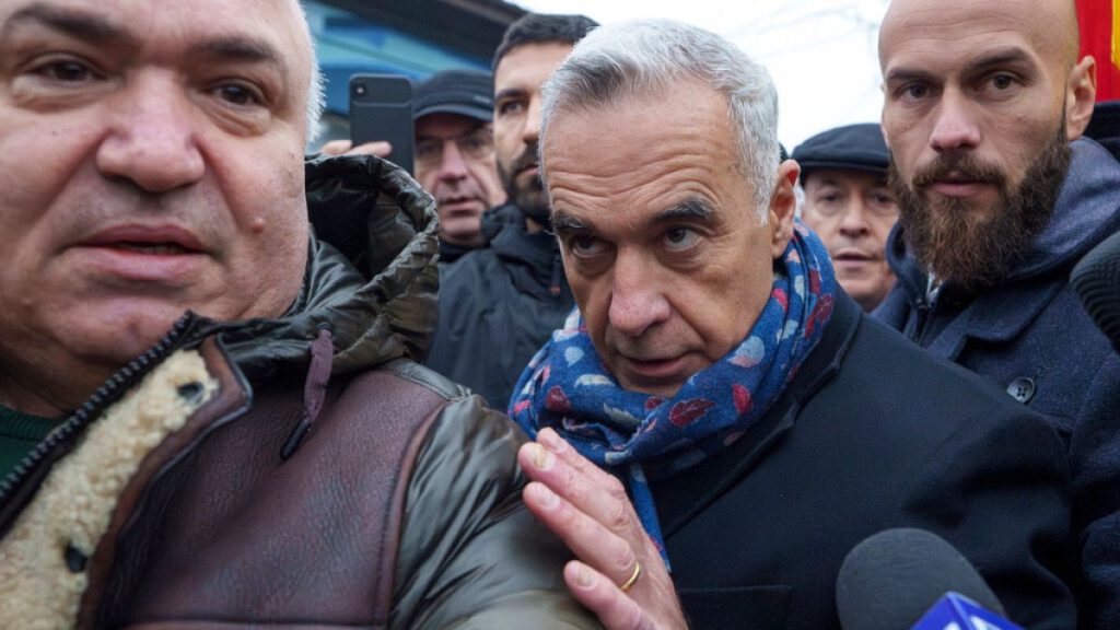 Calin Georgescu, makes his way, surrounded by media, to a closed voting station after Romania