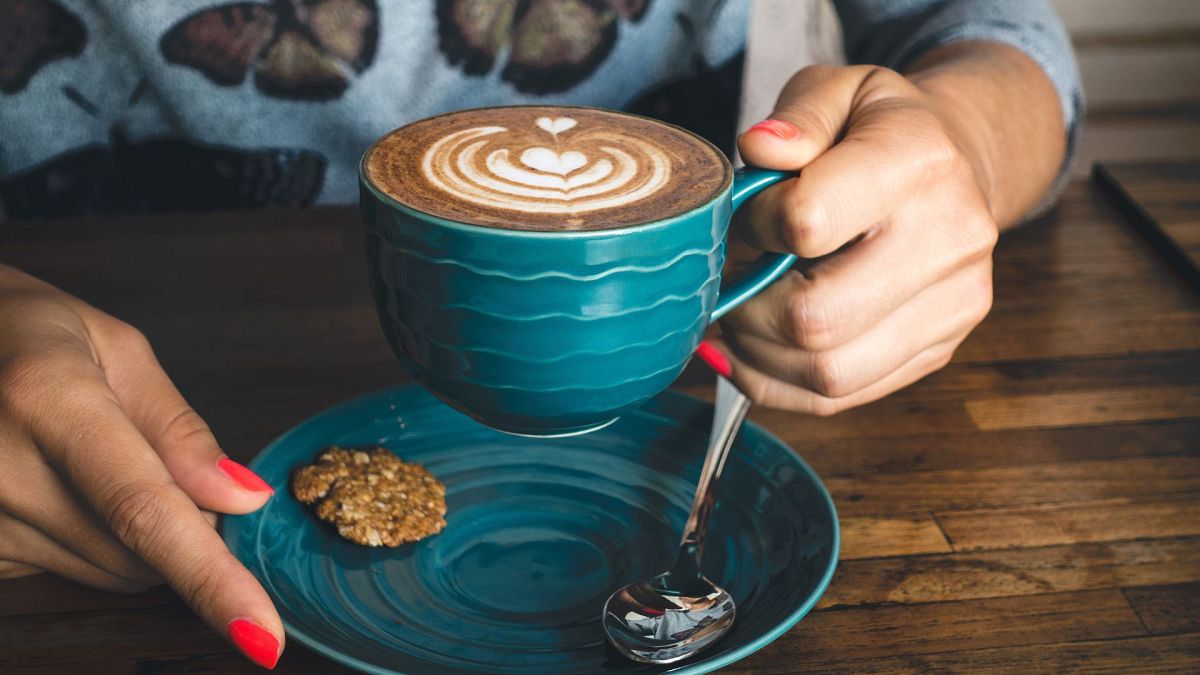 A person holding a cup of coffee.