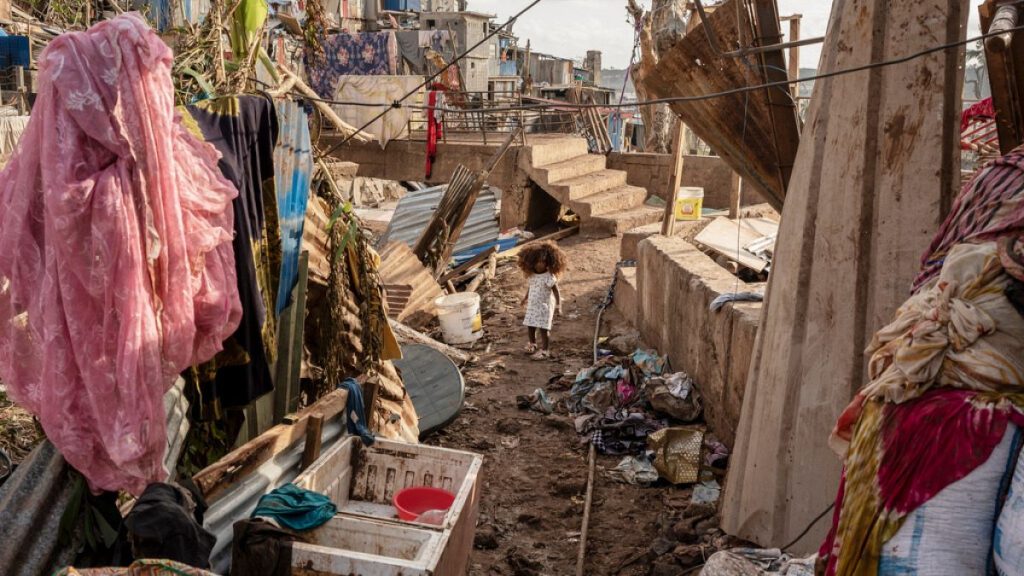 A young girl walks in the Kaweni slum on the outskirts of Mamoudzou, in the French Indian Ocean island of Mayotte after Cyclone Chido, Thursday, Dec. 19, 2024.